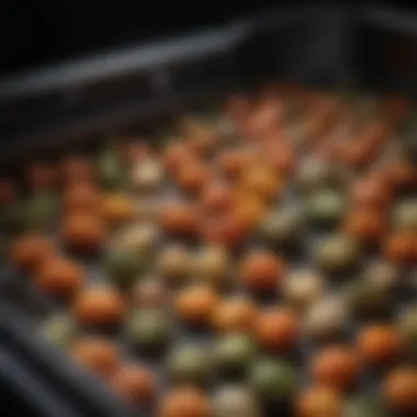 A close-up of crispy vegetables emerging from an air fryer basket.